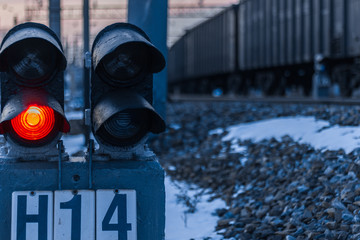 foreground: red light semaphore; in the background: a train going to the distance
