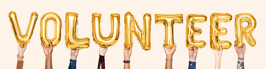 Yellow gold alphabet balloons forming the word volunteer