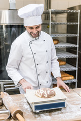smiling baker weighing raw dough on kitchen scales