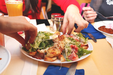 Girls eat Caesar salad in the restaurant