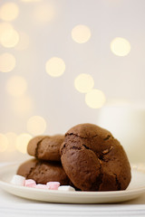 Homemade chocolate cookies and milk on festive bokeh  lights background