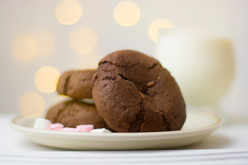 Homemade chocolate cookies and milk on festive bokeh  lights background