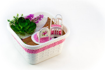 Hand Maid, a hobby pink toy room with a cot for baby. The room also has flowers on the white sand.