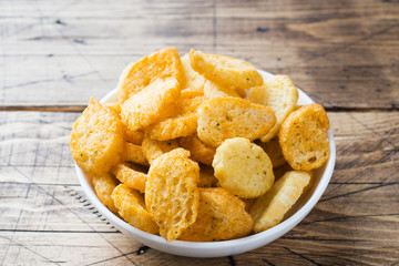 Croutons of white bread baguette with spices in dishes. Wooden background