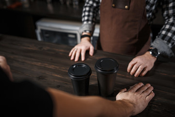 The buyer buys coffee at a bar in a modern cafe. Close-up