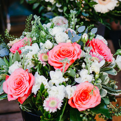 Beautiful bouquet with pink roses on a showcase in a French shop outside.