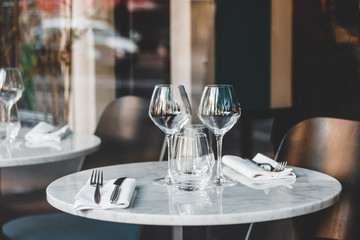 Table setting in a French restaurant. View through a window from a street.