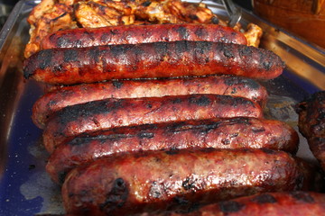 Grilled smoked sausages and meatballs outdoors. Meat baked on the grill bbq. Meat delicacies. Sausages homemade sausages on the grill. Street food. Festival of street food.