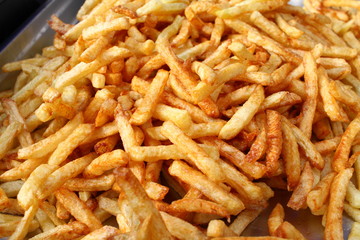 Tasty french fries full frame photo. Fat oiled French fries. Diet killing fried potatoes. Pile of fried potatoes. Potato chips background patter. French fries wallpaper. USA fast food concept.