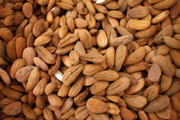 Almonds. Background of big raw peeled almonds situated arbitrarily. Nuts wallpaper pattern. Clipping path. Peeled almonds close up. For vegetarians. Nut pattern.