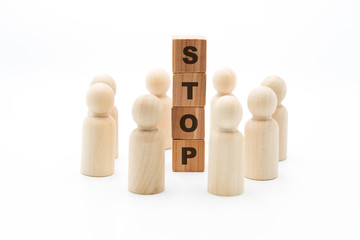 Wooden figures as business team in circle around word STOP