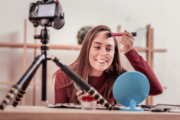 Smiling woman putting make up on