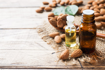 Almond oil in bottle on wooden background. Concept Spa, aromatherapy and medicine. Copy space