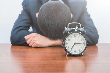 The tired young man with an alarm clock