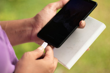 girl hold the phone outside with power bank