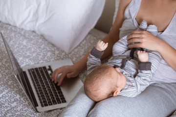 Young mother in home office with computer and her daugher