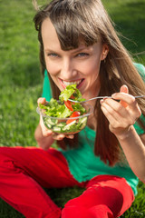 Beautiful caucasian woman eating salad outdoors. Healthy  lifestyle concept