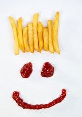 Hair from potatoes, French fries and a face with a smile from ketchup isolated on white background