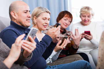 Mature women and man are resting with smartphones