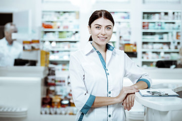 Fototapeta na wymiar Positive delighted girl working in drug store