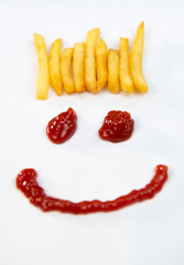 Hair from potatoes, French fries and a face with a smile from ketchup isolated on white background
