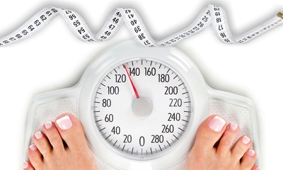 Bare female feet standing on bathroom scale