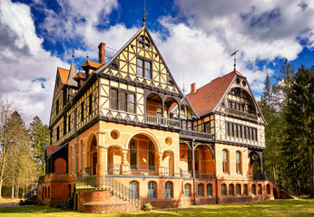 Obraz premium Hunting lodge under sky with clouds in the forest in yellow sands. Germany