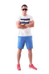 Strong athletic man in summer clothes with sunglasses and crossed arms. Full body isolated on white background. 