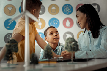 Dreamy kid talking about his secrets with teacher