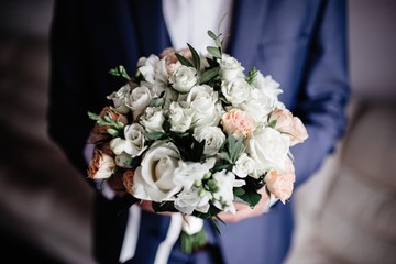 wedding bouquet in hands of bride and groom
