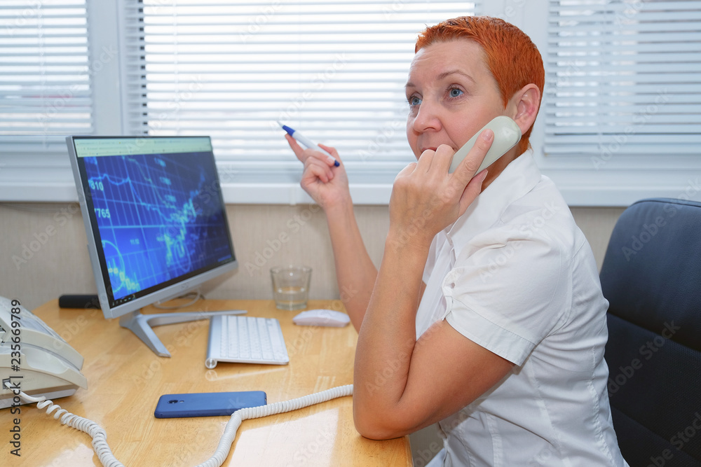 Wall mural beautiful girl stock broker talking on the phone in the office.