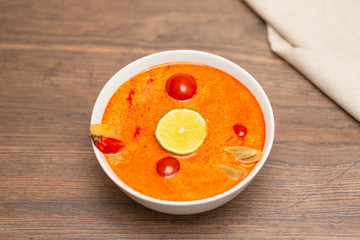 Tom Yum Kung-Thai spicy shrimp soup in white bowl on wooden table