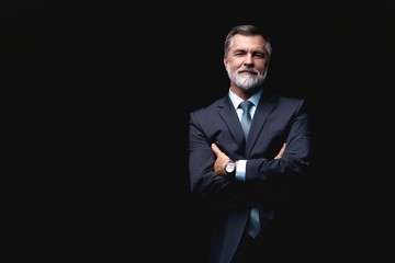 Handsome mature business man isolated on black background