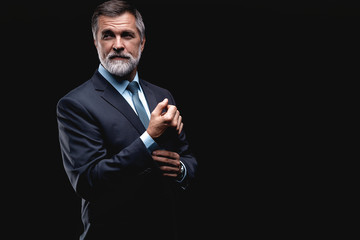 Handsome mature business man isolated on black background