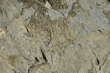 Mountain stone with a natural texture as a design concept. Cracks created by nature on the surface of the stone with a natural color scheme, create a natural textured background. Texture for design .