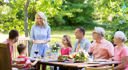 leisure, holidays and people concept - happy family having festive dinner or summer garden party