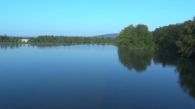 Velka Podvinice Lake is economic and agricultural pond for breeding carp fish, mainly carp and tench, quality water care and shoreline, beautiful blue water in morning with forests, Czech , Europe