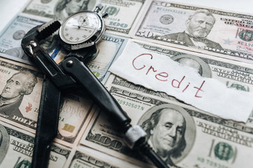 The concept of financial slavery, loans and interest payments to the bank. Dollars and clock, clamped in a wrench. International Monetary Fund.