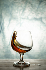 A glass of brandy on a wooden table