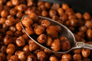 Spoon with roasted chickpeas on backing tray, closeup