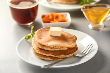 Stack of hot pumpkin pancakes with butter on plate