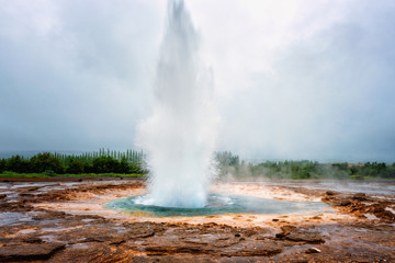 Magnificent Strokkur Geyser erupts the fountain of azure water, popular tourist attraction,...