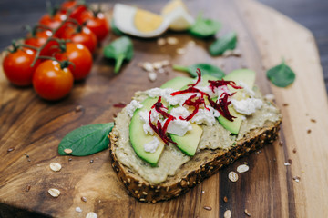 avocado sandwich with feta cheese on wooden background