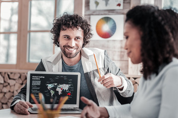 Pleased curly-haired man looking at pretty female