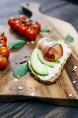 avocado sandwich with ham on wooden background