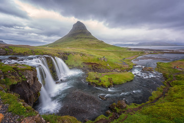 Famous Kirkjufellsfoss waterfall with Kirkjufell (church mountain) on the background, beautiful panoramic landscape, iconic view of the Snaefellsnes peninsula, Iceland