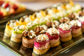 Catering sweets, closeup of various kinds of cakes on event or wedding reception  - selective focus