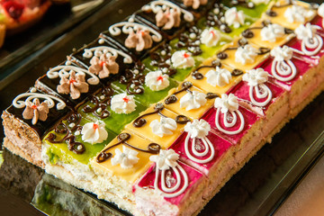 Catering sweets, closeup of various kinds of cakes on event or wedding reception  - selective focus