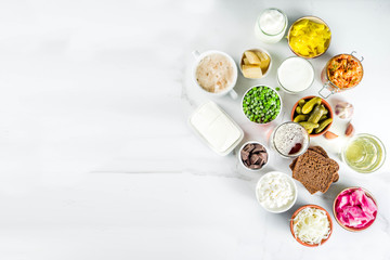 Super Healthy Probiotic Fermented Food Sources, drinks, ingredients, on white marble background copy space top view