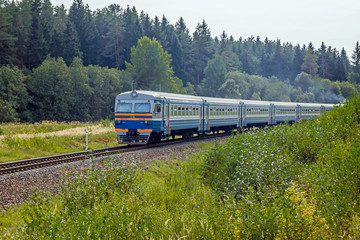 The train travels by rail on a sunny day